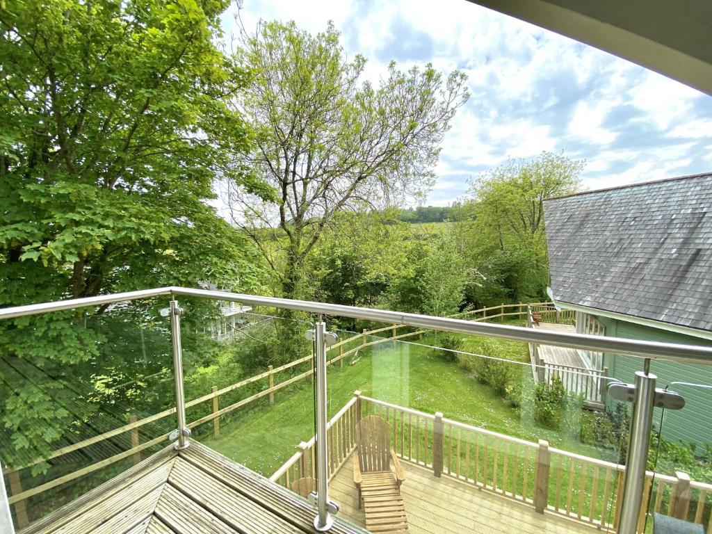 a balcony with a view of a yard at Trewhiddle Retreat V11 by Together Travel - Luxury 4-Bedroom Villa in St Austell