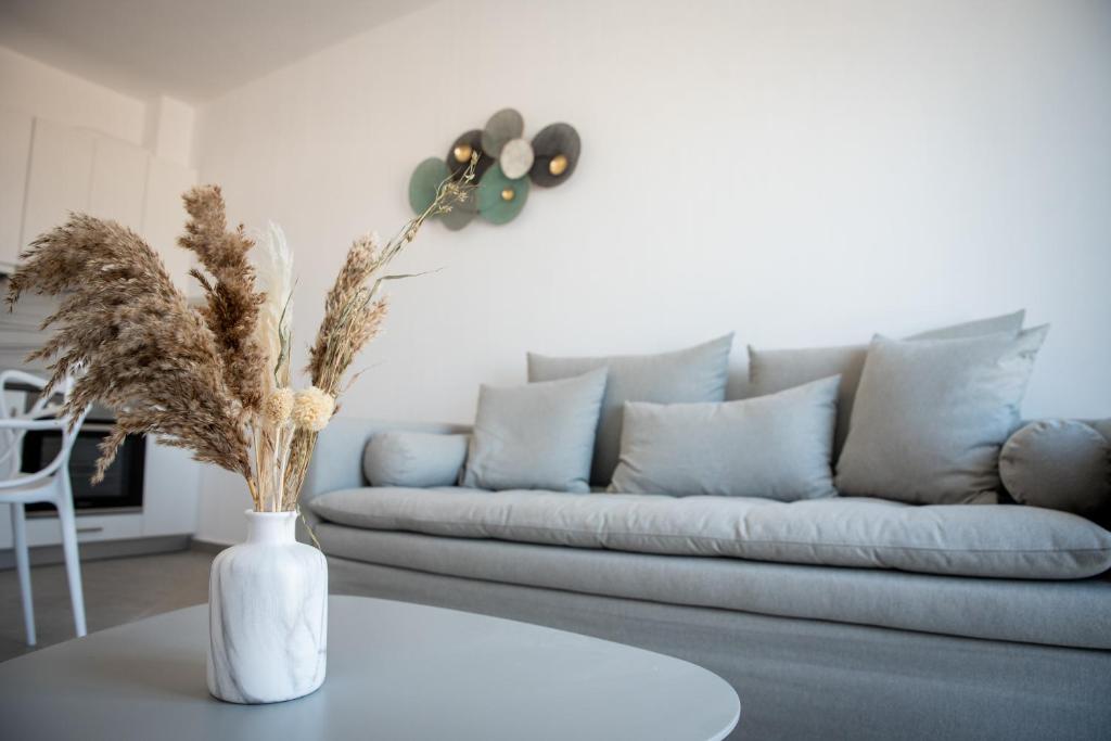 a living room with a couch and a vase with dry grass at Grey Comfort in Glinado Naxos