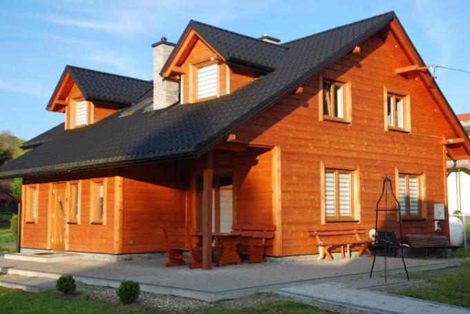 a large wooden house with a black roof at Pod Żurawiem in Bóbrka