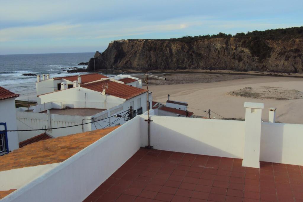 
a beach with a lighthouse on top of it at Odeceixe Beach Apartments in Odeceixe

