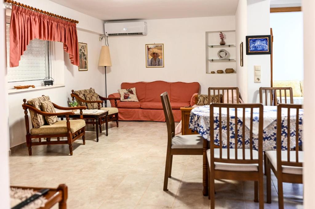 a living room with a couch and a table and chairs at morfo's sunset in Sounio