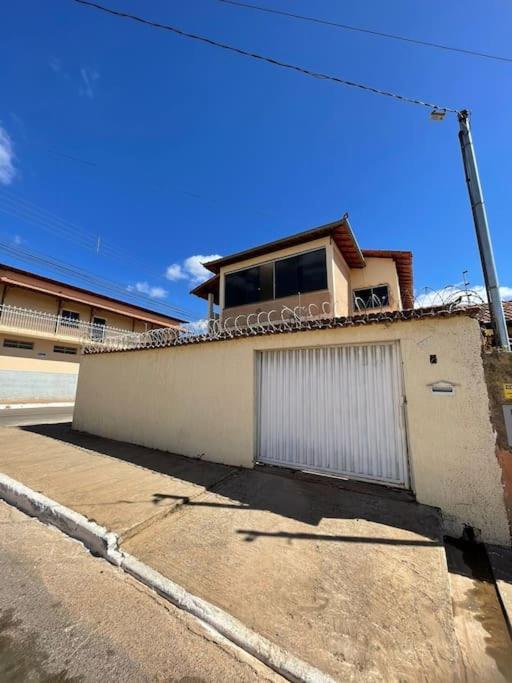 a white building with a window on top of it at Casa 3 quartos 6 pessoas garagem in Coração de Jesus