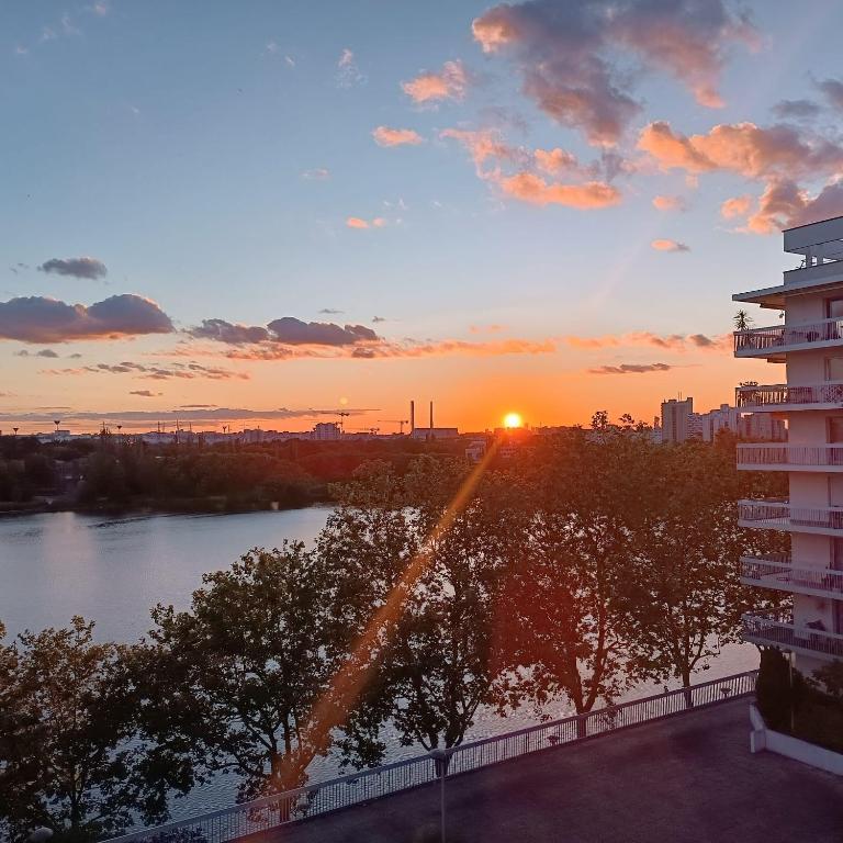 - un balcon offrant une vue sur le coucher de soleil dans l'établissement Chambre chez Casa Créteil, à Créteil