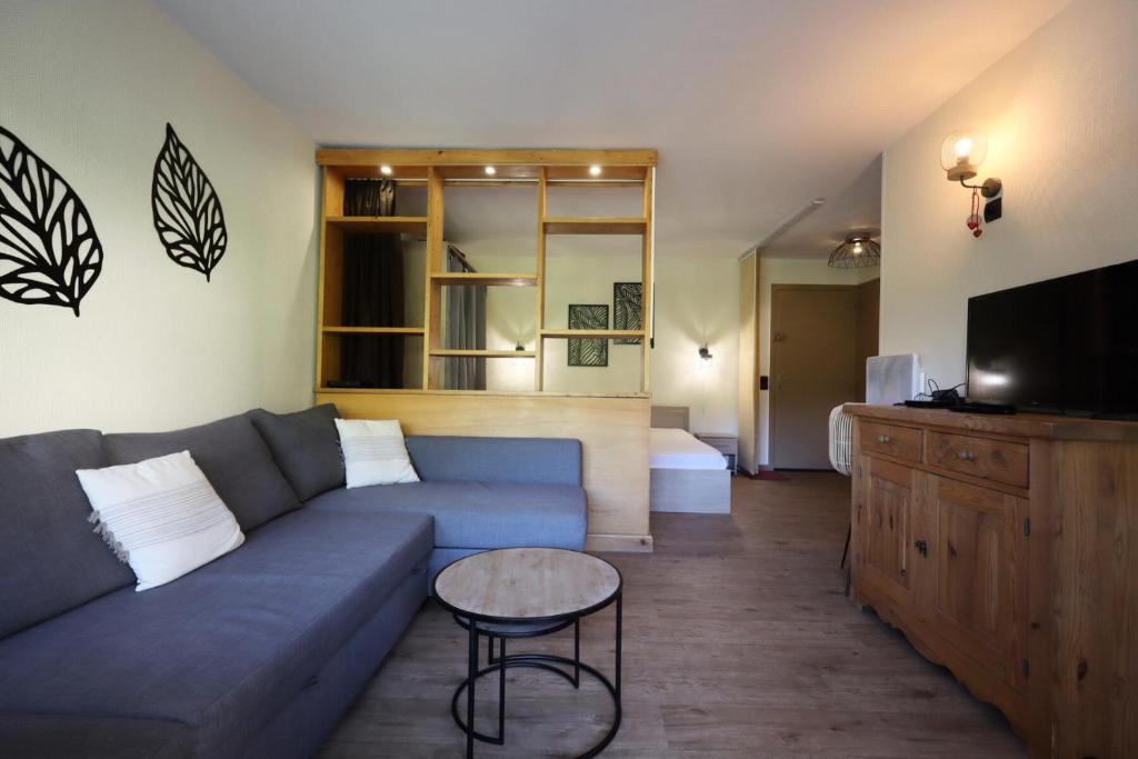 un salon avec un canapé bleu et une télévision dans l'établissement Résidence Prarion 1 - Prarion 2 MAE-4874, aux Houches