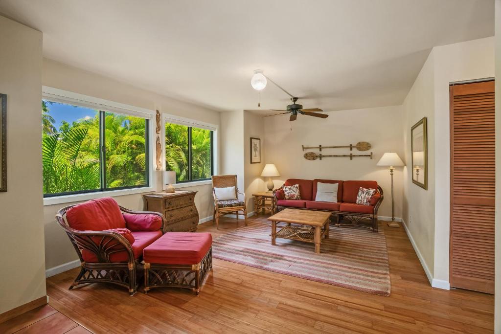 a living room with red chairs and a couch at (HH9B) Classic Hawaiian Hale Honu 2br 2ba in Princeville
