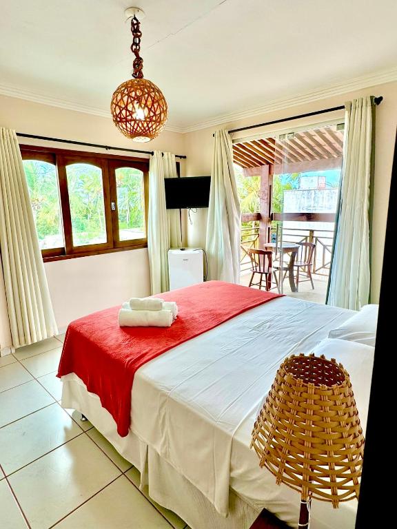 a bedroom with a large bed with a red blanket at Parcel do Gostoso Pousada in São Miguel do Gostoso