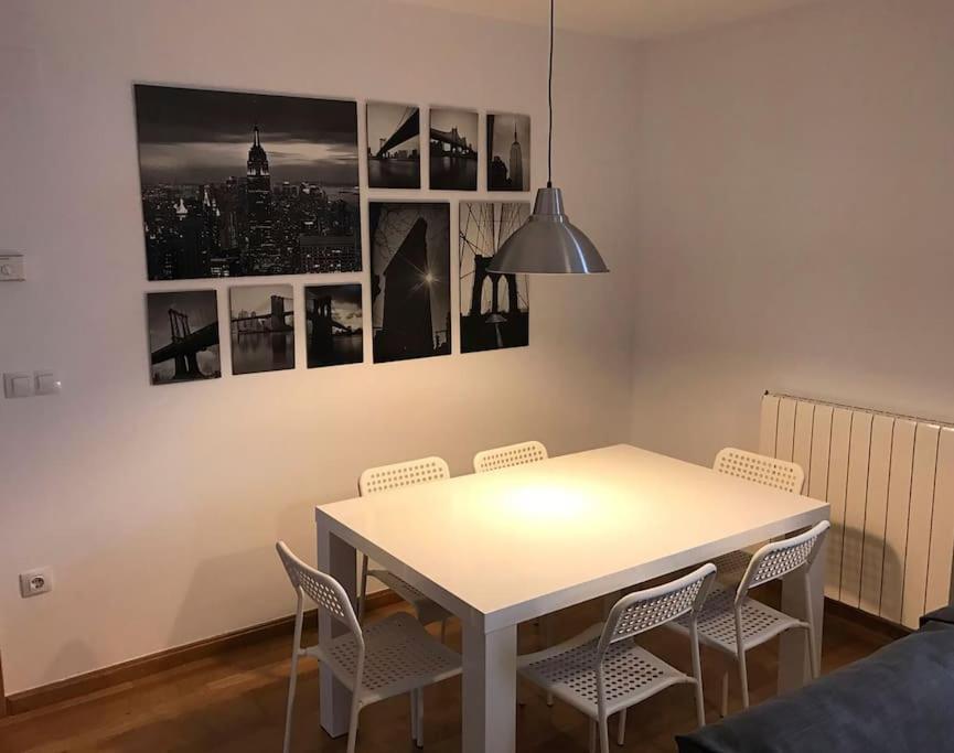 a white dining room table with chairs and pictures on the wall at Apartamento la Abadía en Tramacastilla in Tramacastilla de Tena