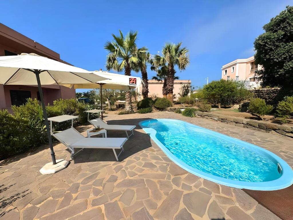 a swimming pool with a table and chairs and an umbrella at Marchetti Home in Pantelleria