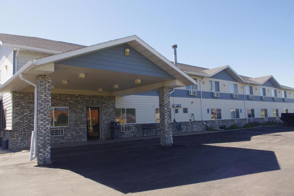 a large white building with two pillars in a parking lot at Selby Motel in Selby