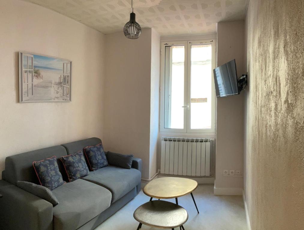 un salon avec un canapé et une table dans l'établissement appartement cosy - 2 chambres, situé en Centre Ville, à Nice