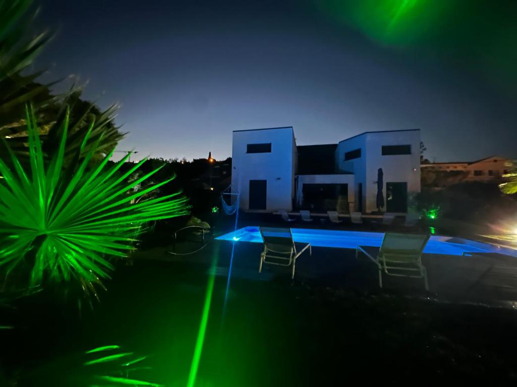 une maison avec une piscine et des lumières vertes la nuit dans l'établissement Entre st Raphael, st Tropez a 200M des calanques, aux Issambres