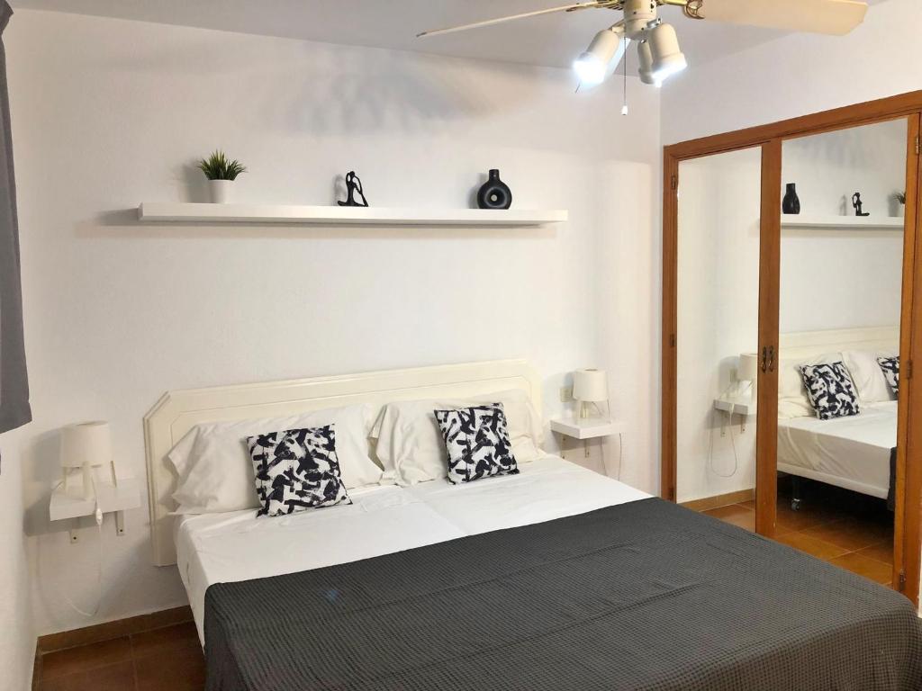 a bedroom with a bed with black and white pillows at Apartamento Elisa en Garden City con piscina climatizada in Playa Fañabe