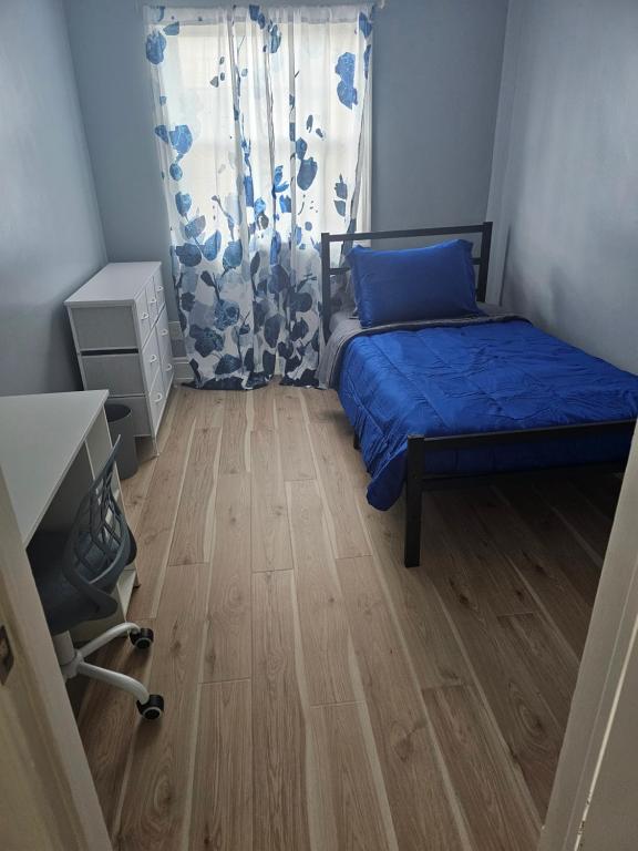 una piccola stanza con un letto e una finestra di Small cozy room, shared bathroom a Baltimora