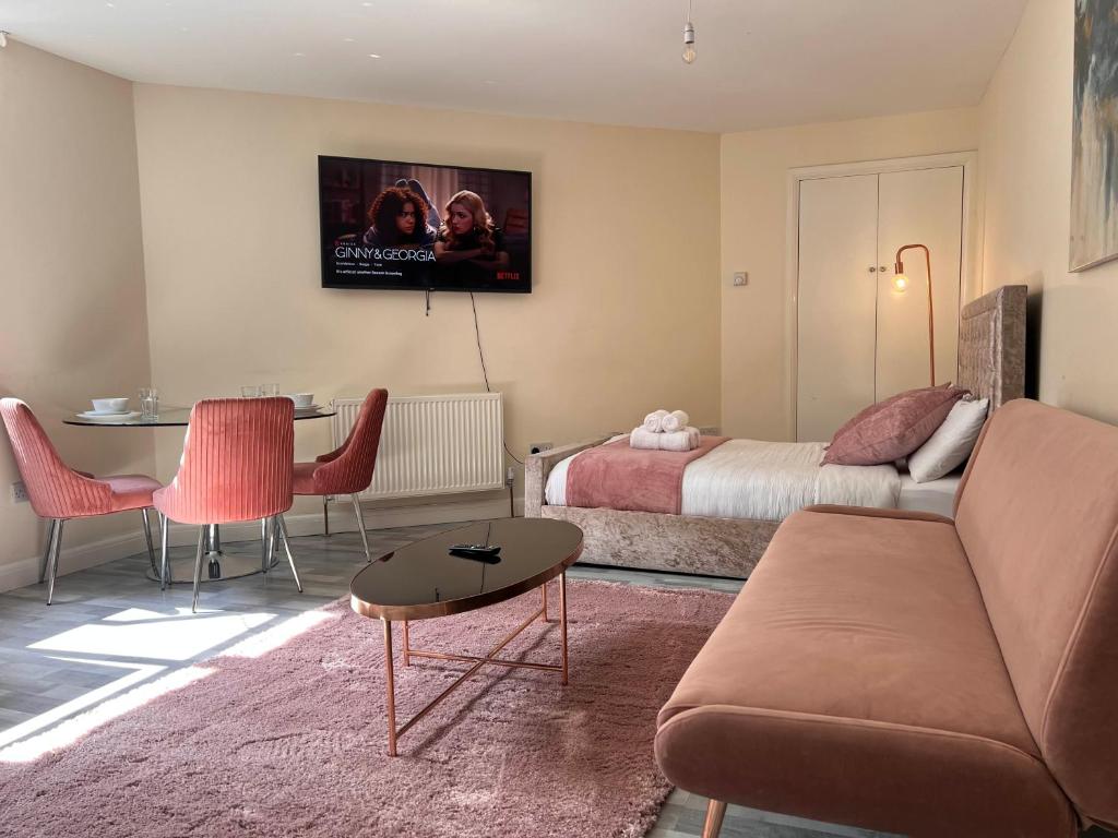 ein Wohnzimmer mit einer Couch und einem Bett in der Unterkunft Haven Homes - Central Luton Studio Apartments in Luton