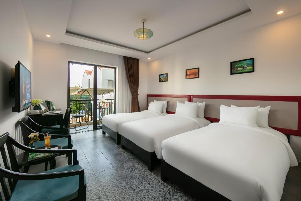 Postel nebo postele na pokoji v ubytování Hoi An Rose Garden Hotel