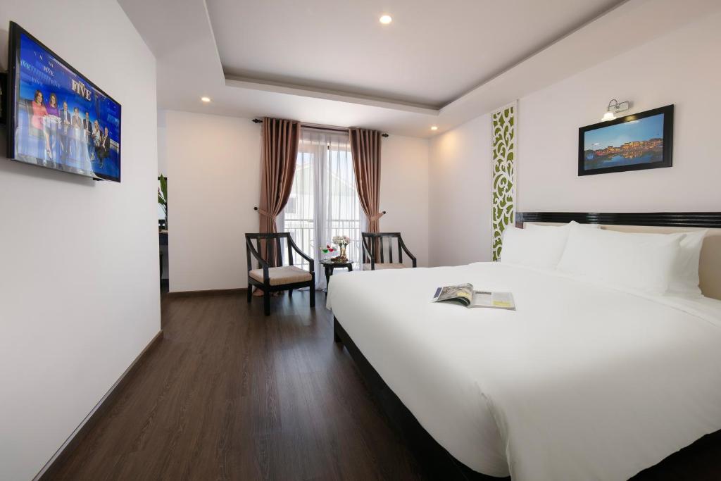Postel nebo postele na pokoji v ubytování Hoi An Rose Garden Hotel
