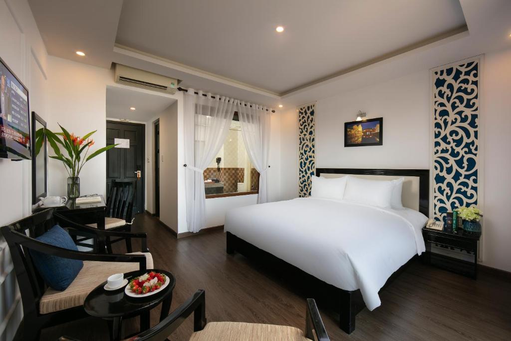 Postel nebo postele na pokoji v ubytování Hoi An Rose Garden Hotel