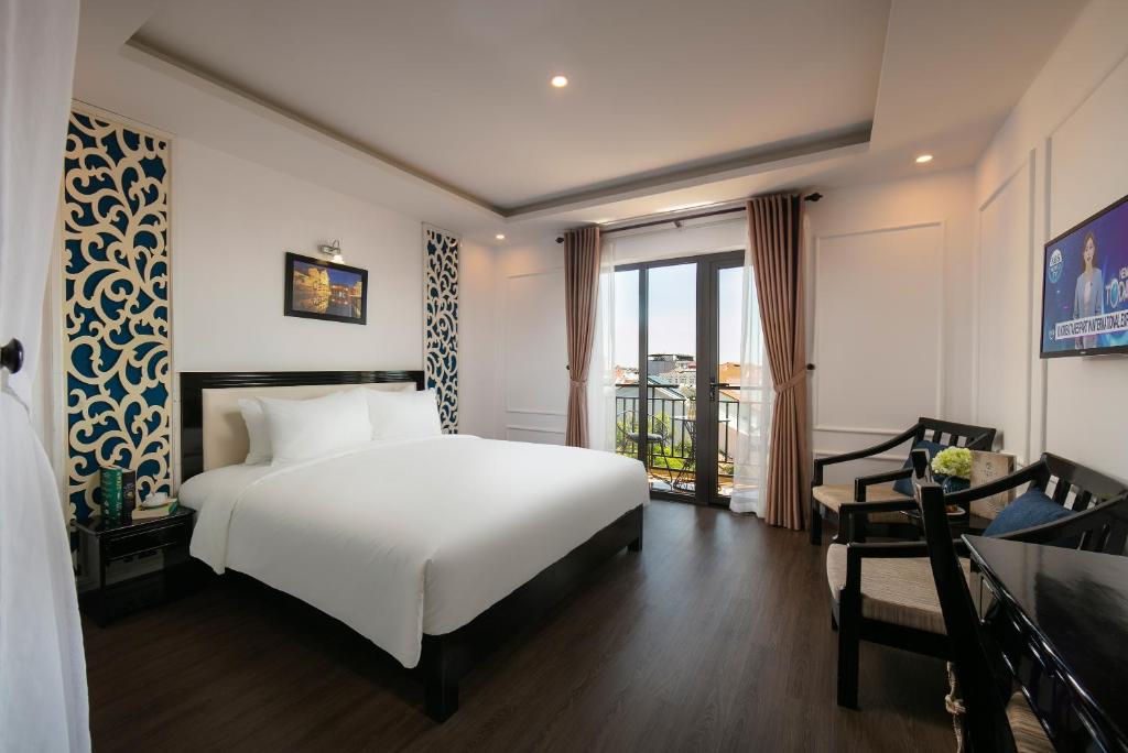 Postel nebo postele na pokoji v ubytování Hoi An Rose Garden Hotel