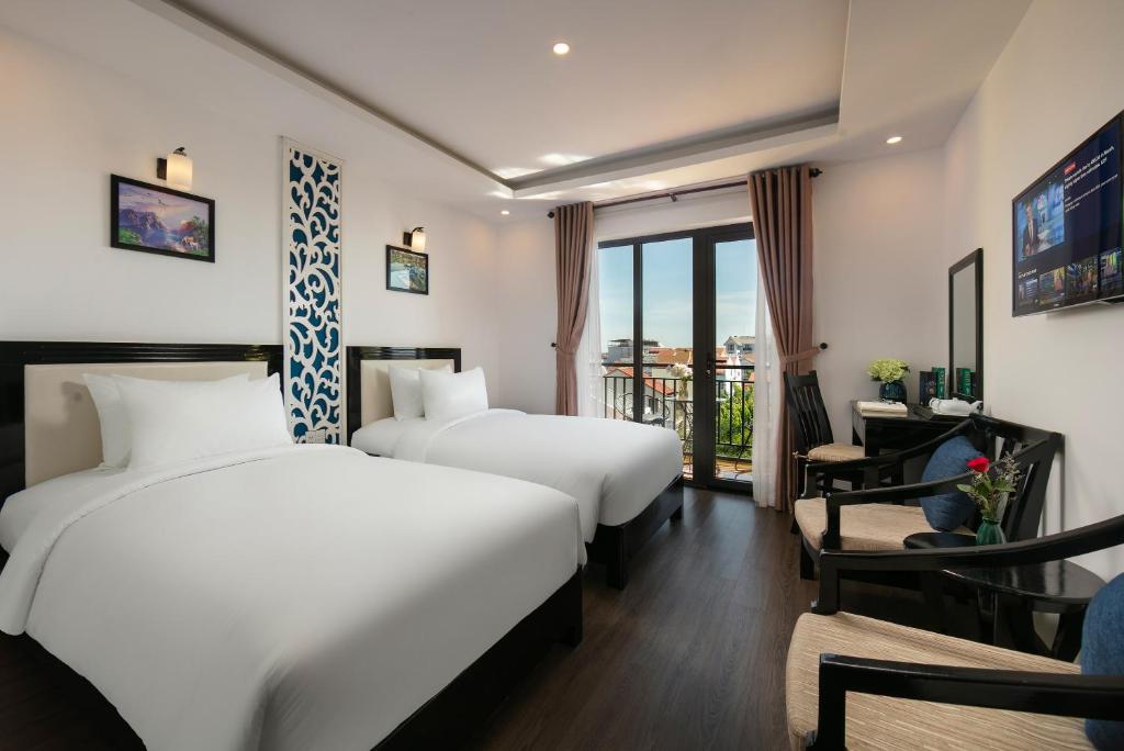 Postel nebo postele na pokoji v ubytování Hoi An Rose Garden Hotel
