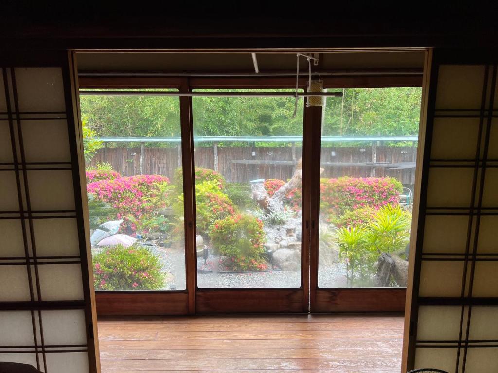 直島町にある一日限定一組の古民家の宿なんでもんのピンクの花の咲く庭への開口ドア