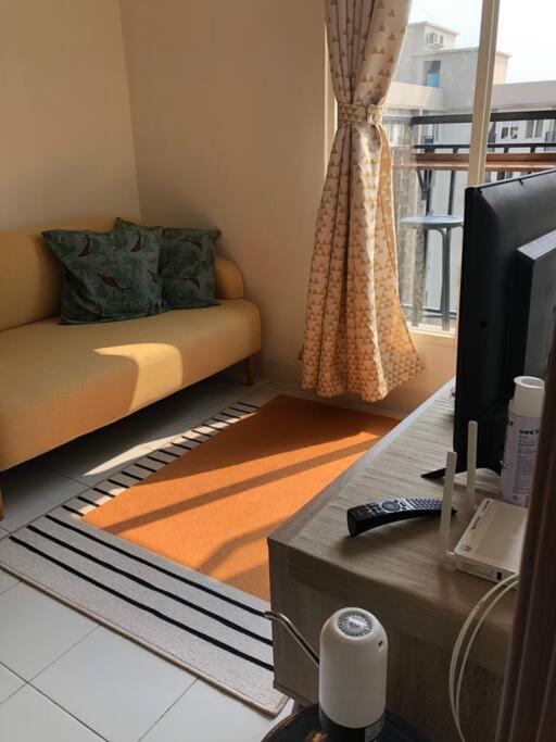 a living room with a couch and a television at 2BR Podomoro Golf View Cimanggis with Netflix near exit Toll Jagorawi in Tjikuda Tiga