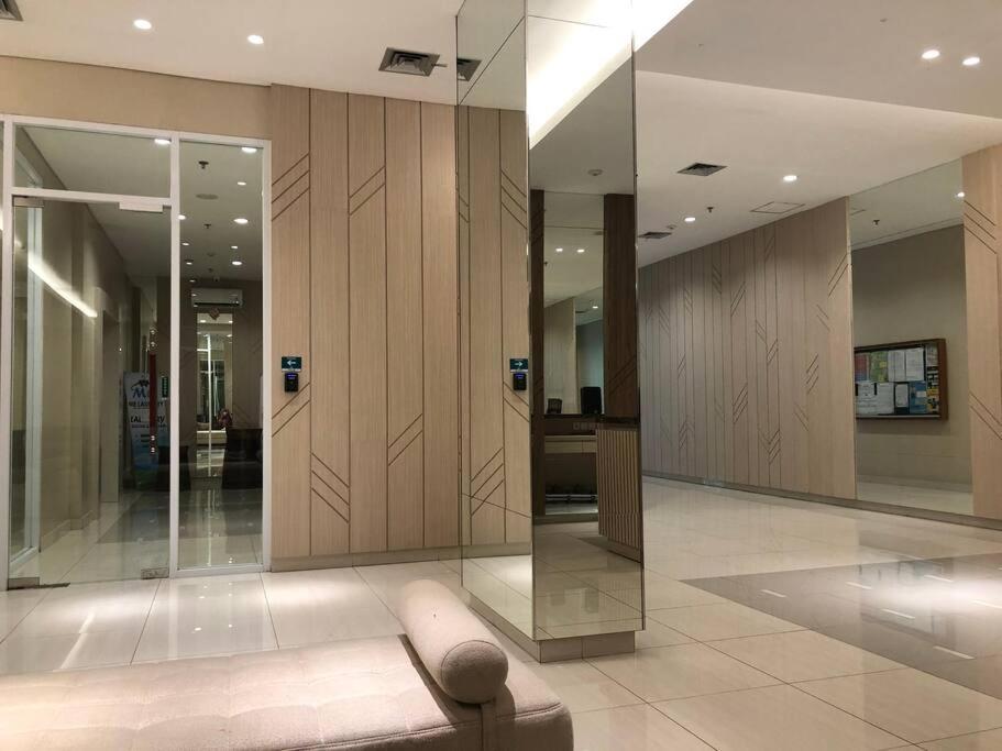 a lobby with wood paneling and a glass wall at 2BR Podomoro Golf View Cimanggis with Netflix near exit Toll Jagorawi in Tjikuda Tiga
