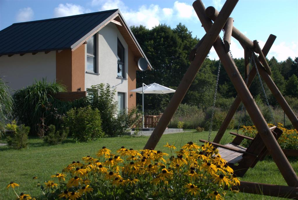a swing in a yard next to a house at Domki Kalinowa14 Kopalino in Kopalino