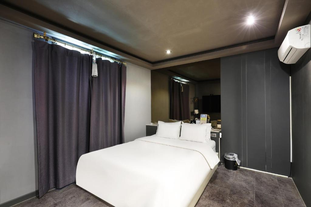 Postel nebo postele na pokoji v ubytování Pyeongtaek Moon Hotel