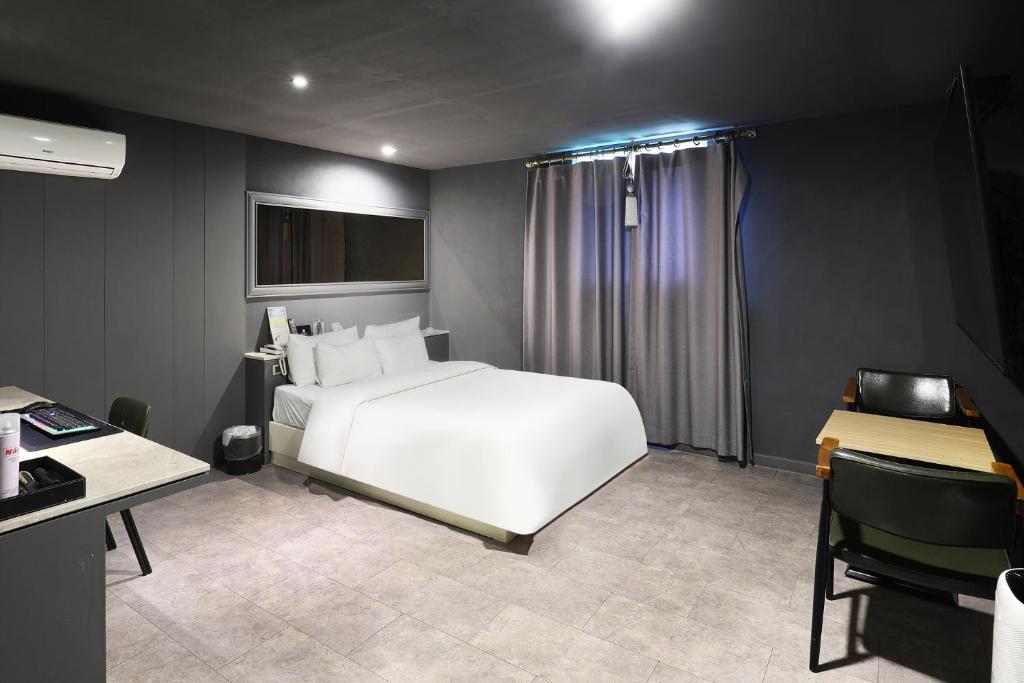 Postel nebo postele na pokoji v ubytování Pyeongtaek Moon Hotel