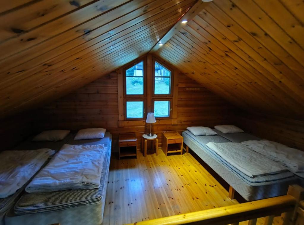 耶姆赛Äijänhonka Cottage的有两张床和一扇窗户的阁楼房间