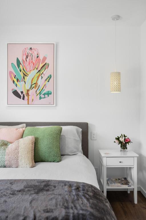 a bedroom with a bed and a nightstand with a table at Rainforest Retreat Fireplace, Bath & Falls Walk in Springbrook