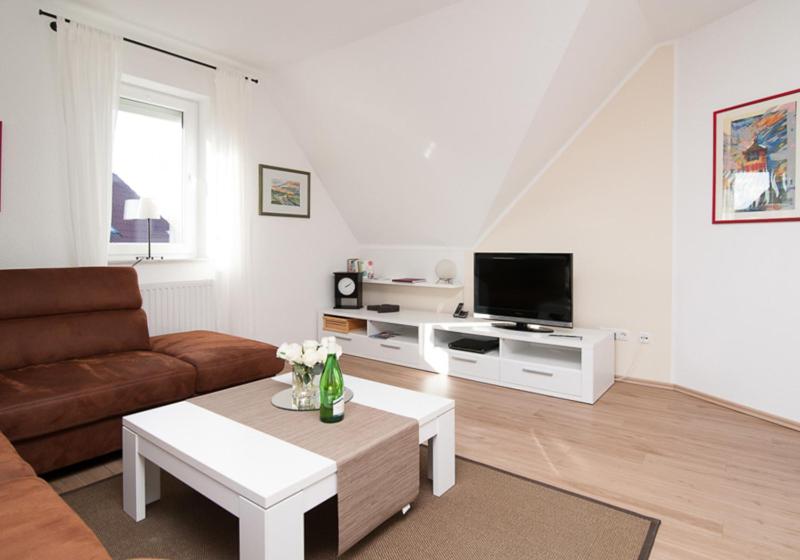 a living room with a couch and a tv at Kiebitznest in Krummhörn