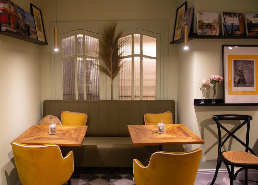 a restaurant with two tables and yellow chairs at Maison Primado B&B in Valencia