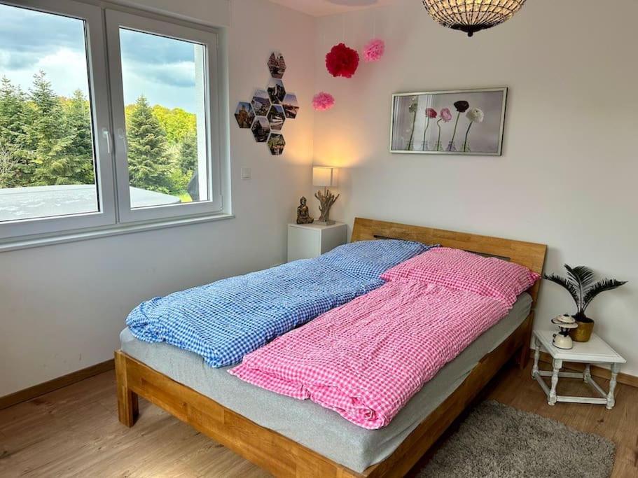 une chambre avec un lit avec une couverture rose et bleue dans l'établissement Mosel Urlaub Stabenhof - Whirlpool, Natur und Grill, à Brodenbach
