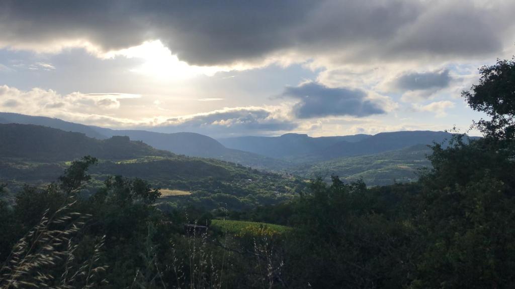 une vue sur une vallée où le soleil brille à travers les nuages dans l'établissement La Bergerie, à Lauroux