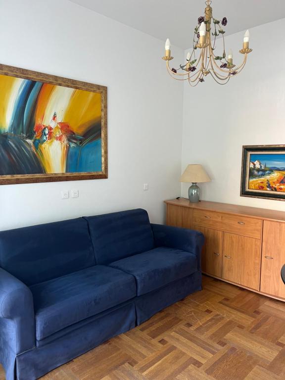 - un canapé bleu dans le salon orné d'un tableau dans l'établissement Long stay nearby Mariottes H Nice town, à Nice