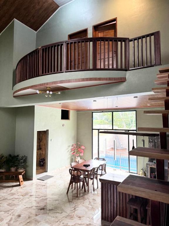 a living room with a table and a balcony at Villa Sibolangit Satu Hati near Hillpark with private pool in Bandarbaru
