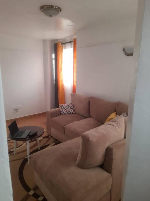 a living room with a couch and a table at Nyona Homes in Kalimoni