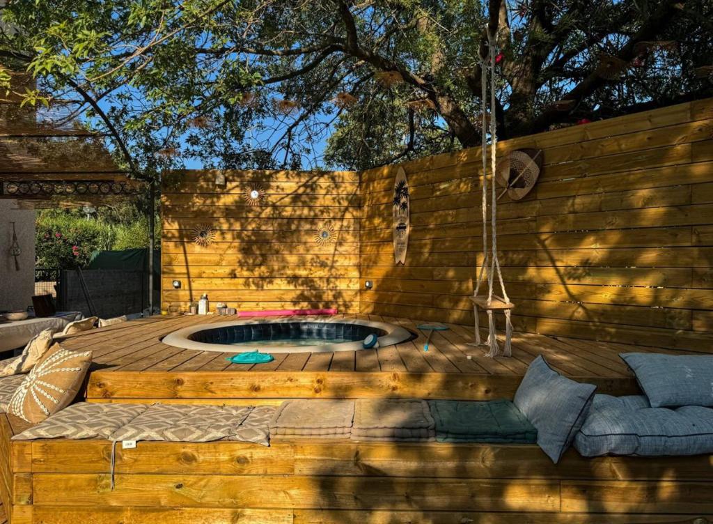 une terrasse en bois avec un bain à remous dans l'arrière-cour dans l'établissement Villa tout confort, à Fréjus
