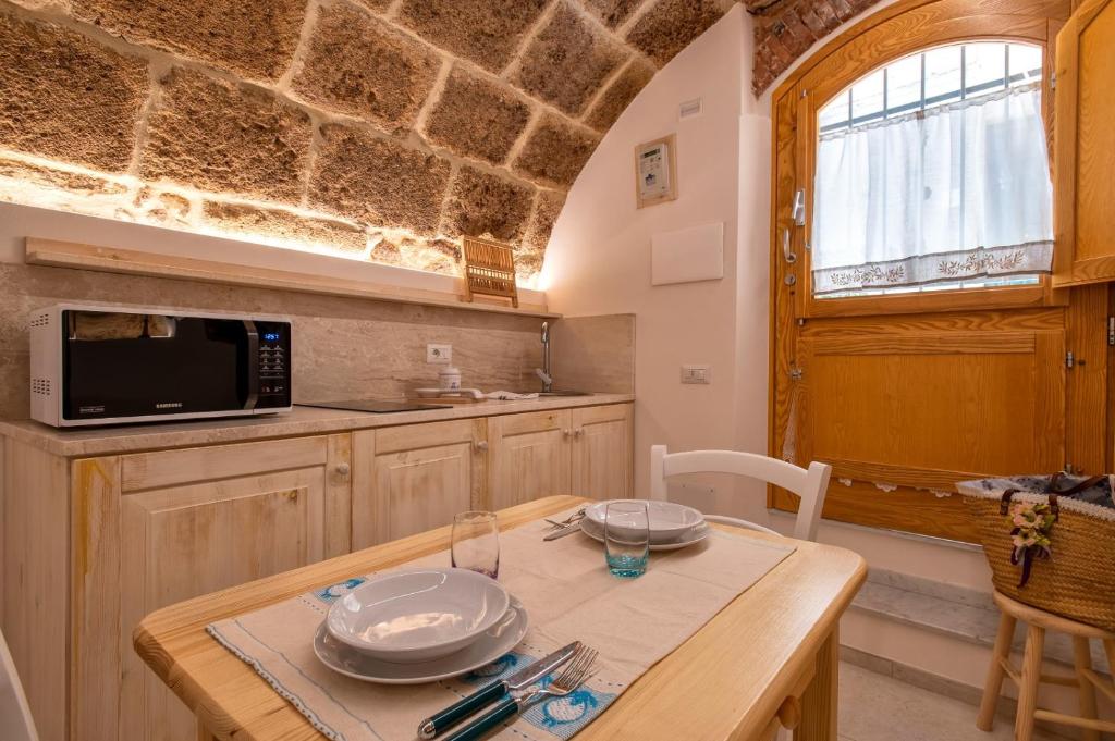 eine Küche mit einem Holztisch, auf dem Teller stehen in der Unterkunft Deliloft in Alghero