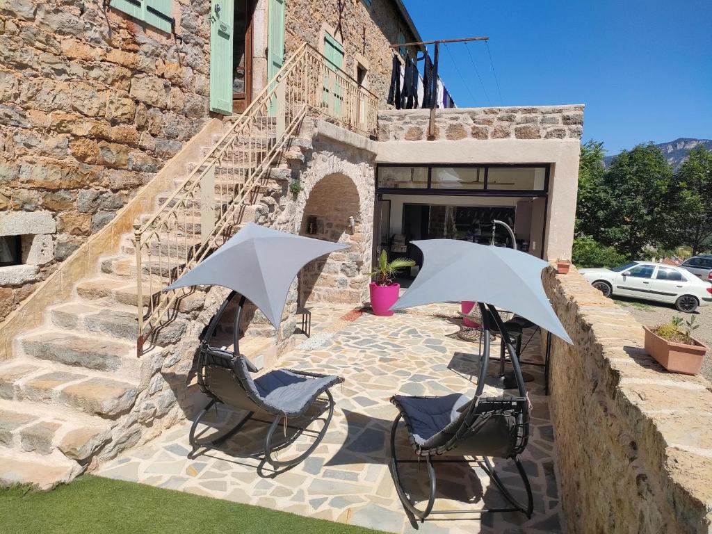 - deux chaises et deux parasols sur la terrasse dans l'établissement lesoleilo, à Mostuéjouls