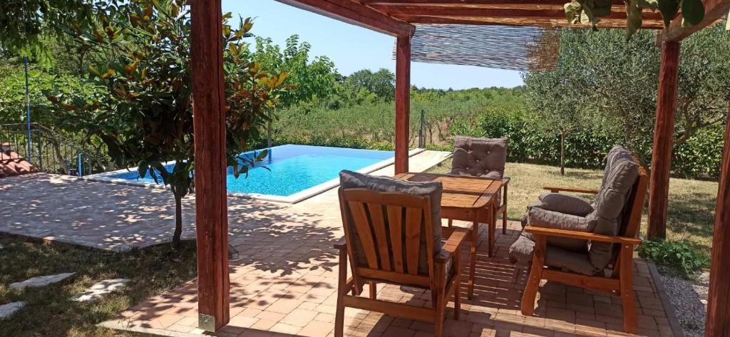 a patio with a table and chairs and a pool at Vila Magnolia in Vilanija