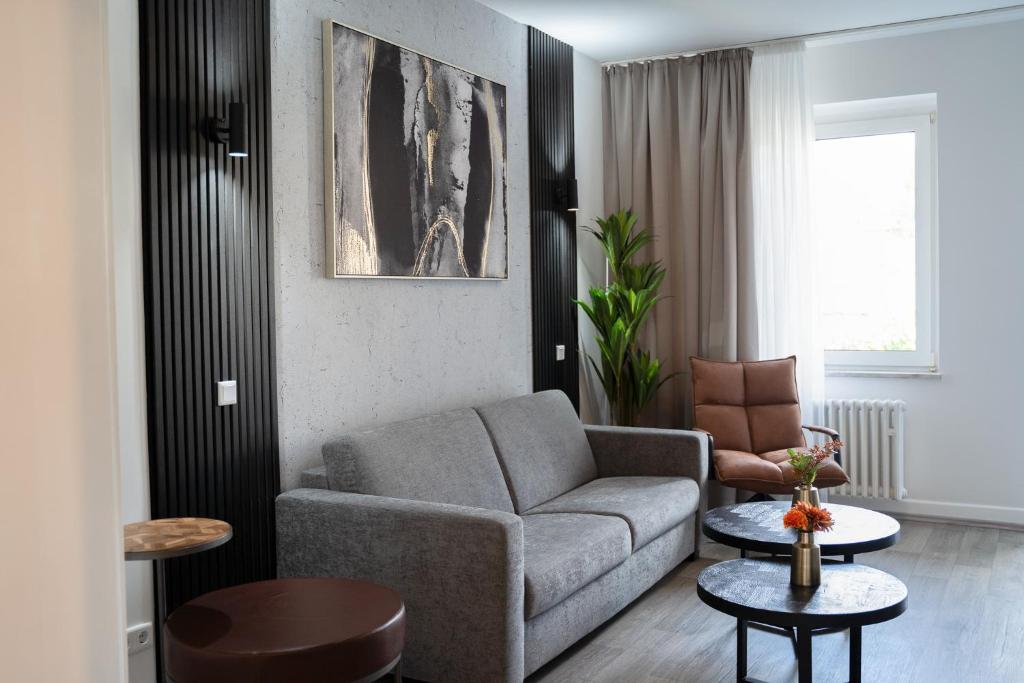 a living room with a couch and a chair at JUNIK Apartments Oberhausen No º11 in Oberhausen