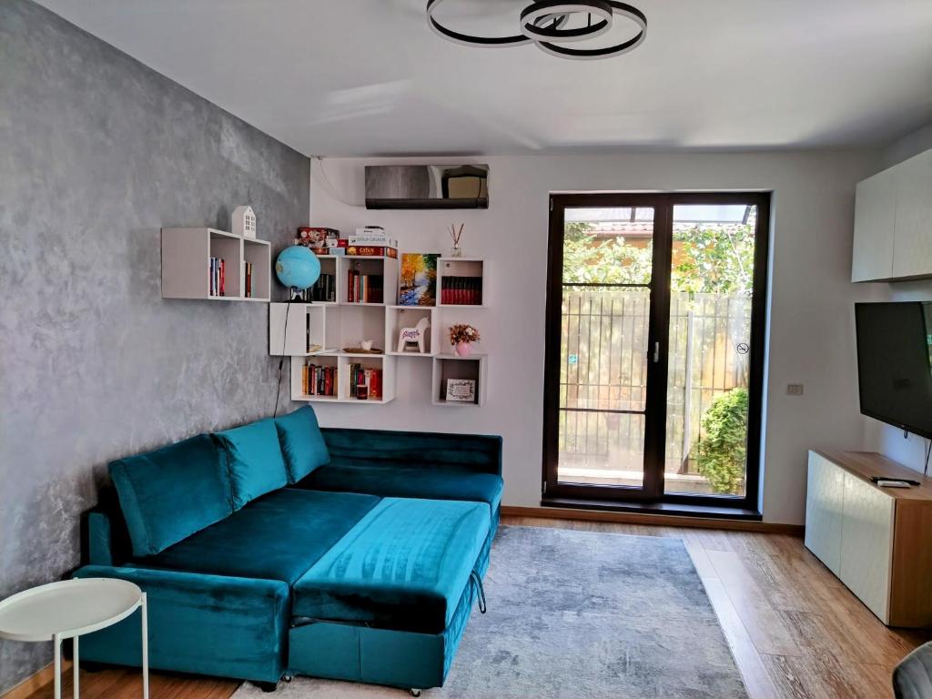 a living room with a blue couch and a tv at Exclusive Living Apartment in Bucharest