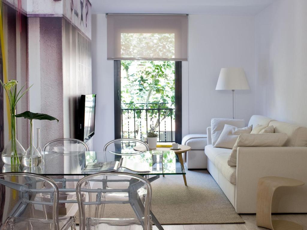 uma sala de estar com um sofá, uma mesa e cadeiras em Eric Vökel Boutique Apartments - Sagrada Familia Suites em Barcelona