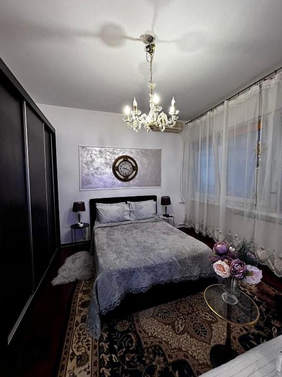 a bedroom with a bed and a chandelier at Mini scala in Bucharest