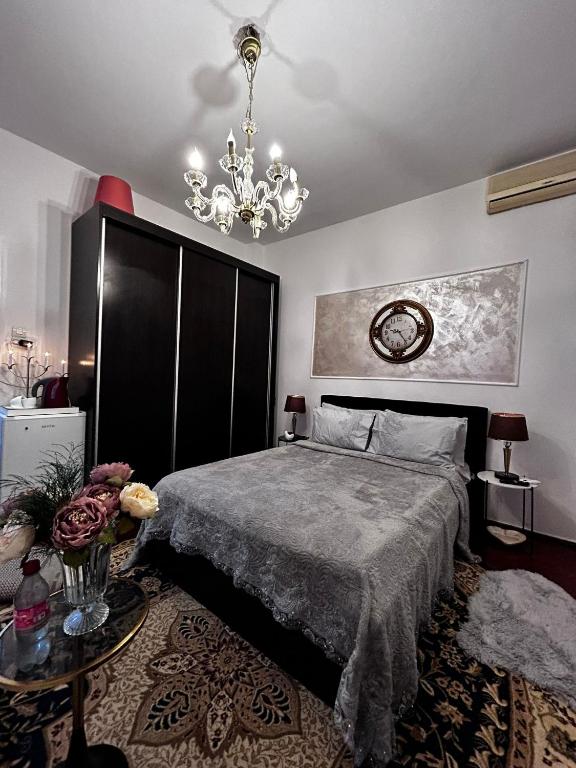 a bedroom with a bed and a chandelier at Mini scala in Bucharest