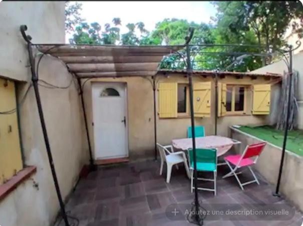 une terrasse avec une table et des chaises dans une maison dans l'établissement appartement proche du stade 2, à Marseille
