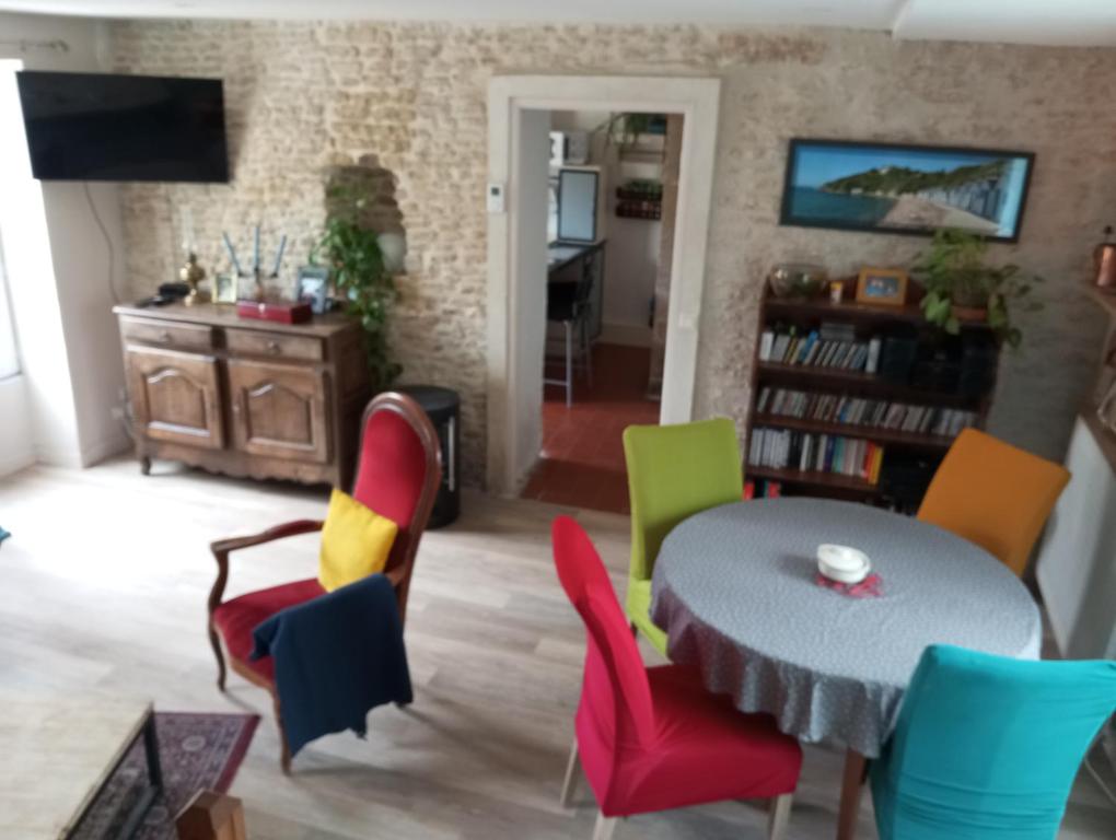 un salon avec une table et des chaises dans l'établissement Maison mer plage du débarquement Caen Nord, à Bernières-sur-Mer