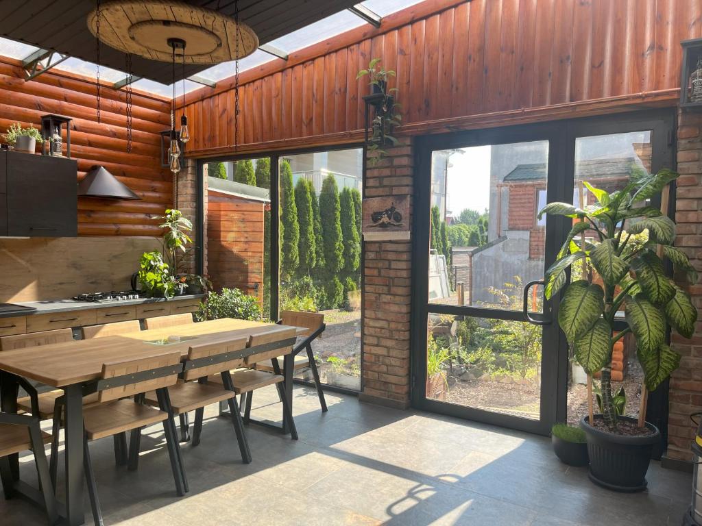 a dining room with a table and a large window at Apartament ORANŻERIA in Kielce